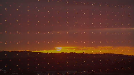 sunset over hills with glowing square pattern animation in sky