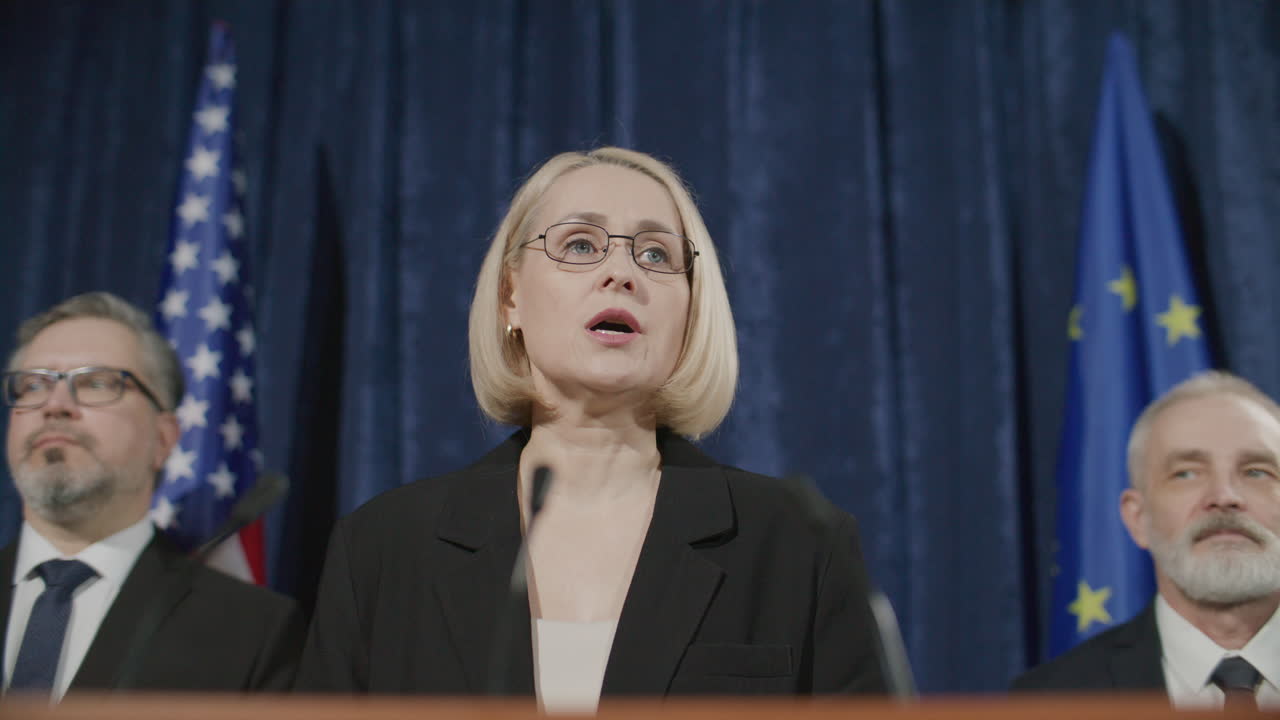 Female Diplomat Speaking from Stage at International Press Conference