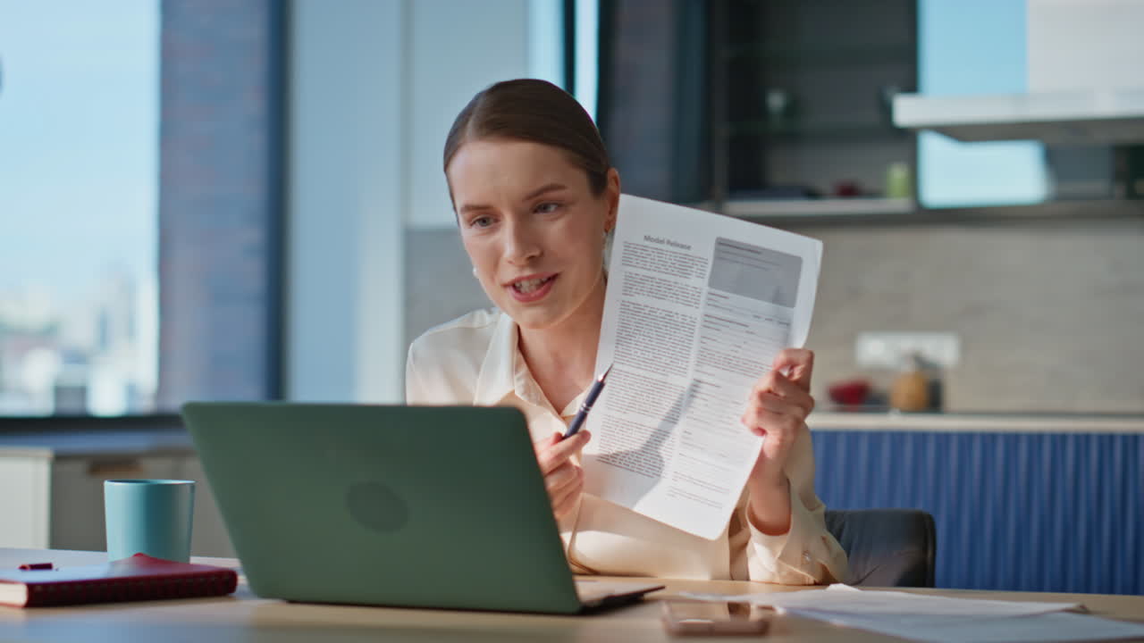 Businesswoman arguing video call showing documents in laptop at home closeup