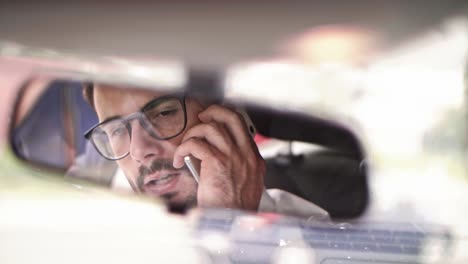 man talking by smart phone in a car