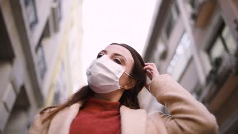 beautiful girl wearing protective medical mask and fashionable clothes stands at street