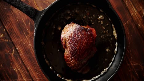 piece of meat fried in oil on pan