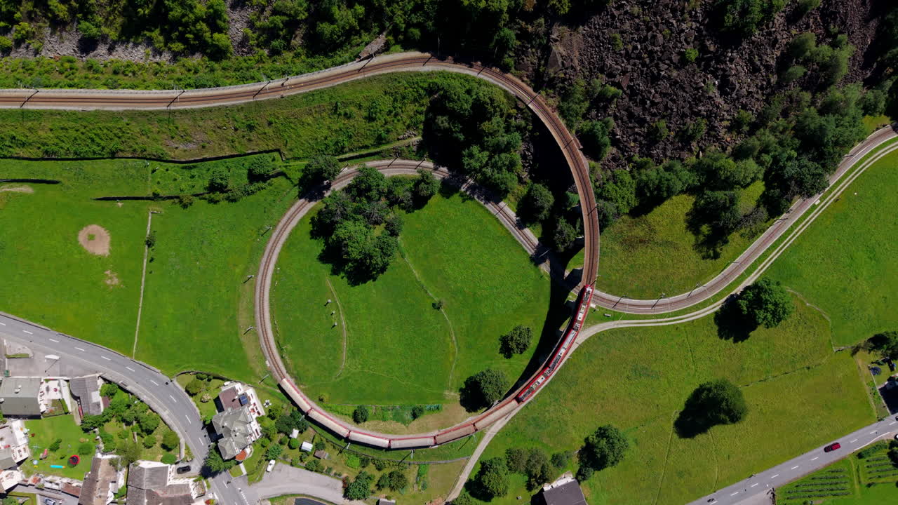 Scenic shot of Bernina red train winding through Swiss landscape