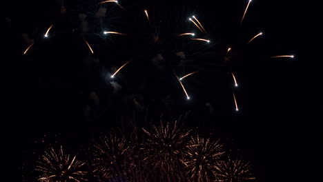 fuegos artificiales, chispas y partículas explosivas en el cielo nocturno