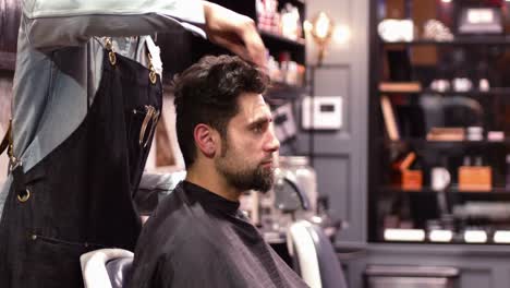 peluquero aplicando crema en el cabello de los clientes