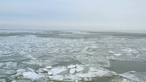 drone flying backwards over melting ice in early spring