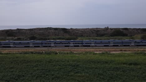 Megadim-Moshav,-Israel---Train-Traveling-Along-the-Coastal-Railway-Line---Aerial-Panning-Shot