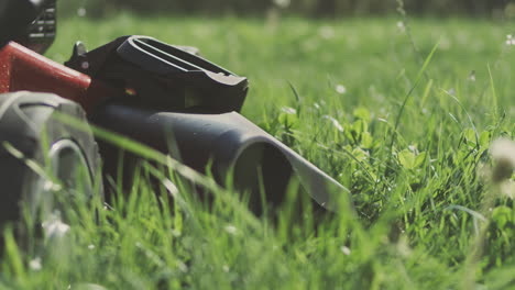 red toy lawnmower in a grassy area