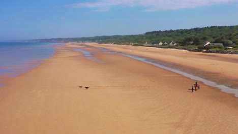 Antenne-über-Hunde-Laufen-Und-Pferd-Und-Reiter-Am-Omaha-Beach-Normandie-Frankreich-Ort-Des-Zweiten-Weltkriegs-D-Day-Invasion-Der-Alliierten