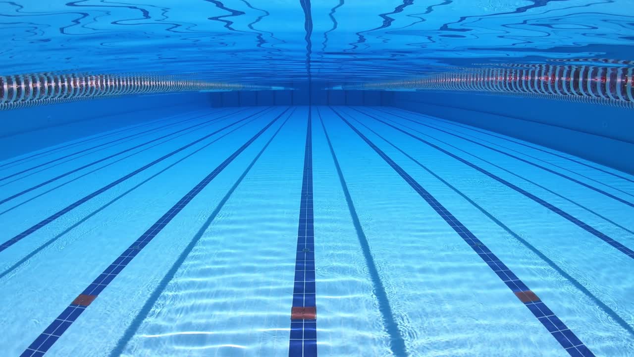 水の背景の下でオリンピックスイミングプール。