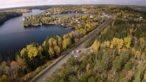 Colorida-Toma-Aérea-De-Vías-De-Tren-Y-Cabañas-Junto-A-Lagos-De-Agua-Fresca-Y-Fría-En-La-Hermosa-Concha-Blanca-De-Canadá