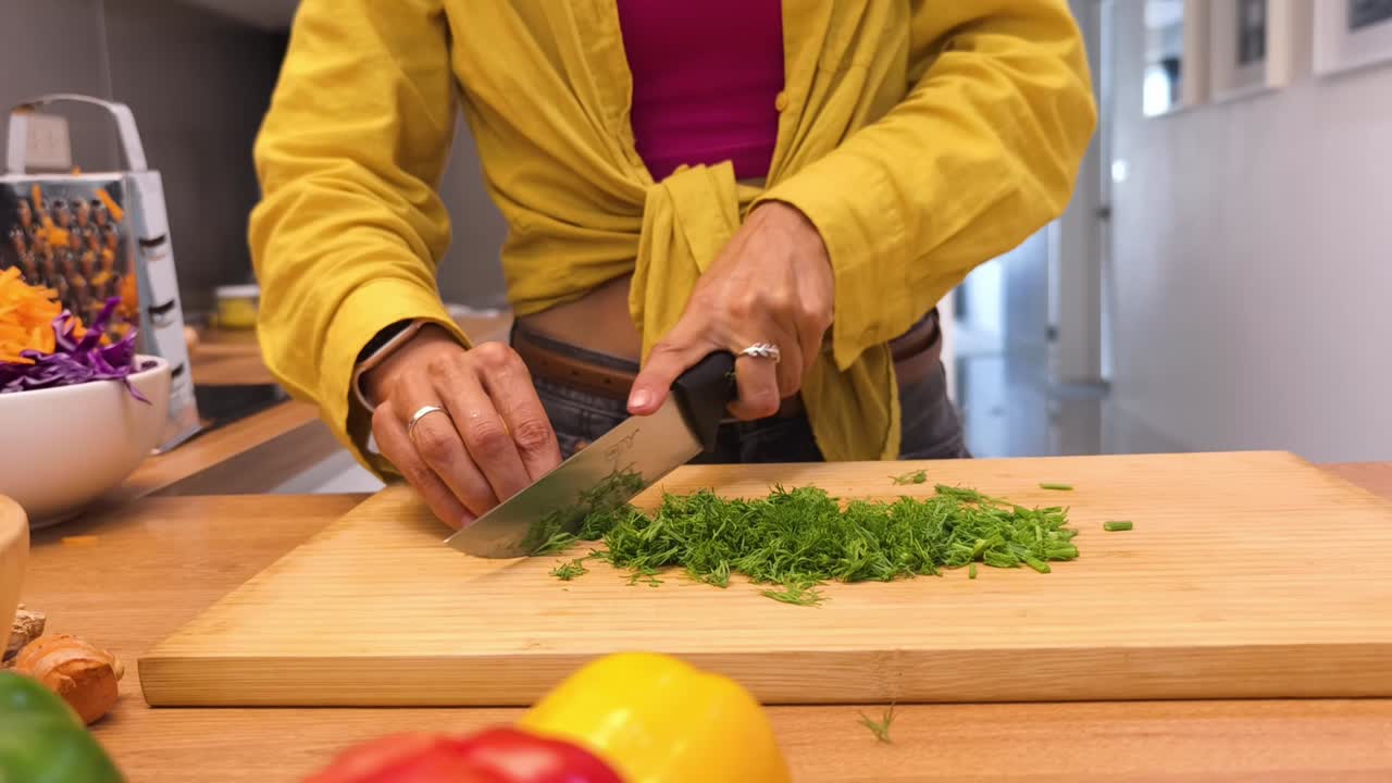 Woman Chopping Dill in a Kitchen