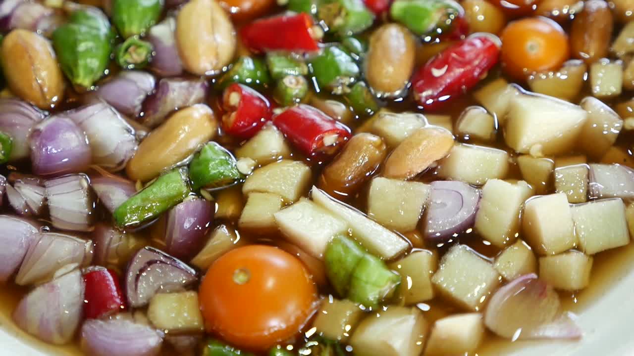 태국식 야자 설탕 소스, 칠리, 땅콩, 생강, 샬롯이 섞인 달콤하고 매운 소스의 클로즈업 영상, 주로 튀긴 생선과 함께 제공