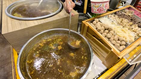 thai street food stall with soup, meatballs and noodles