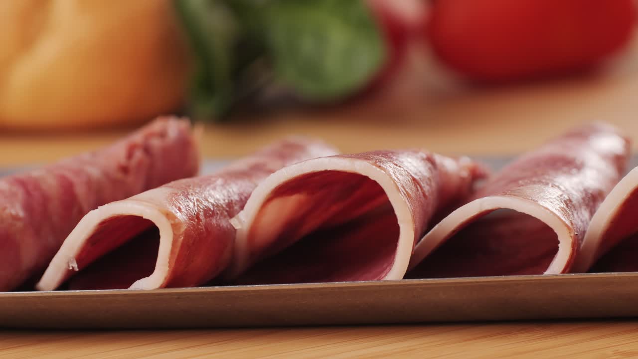 black bull sausage ham, tongue pork dry-cured sausage on a black background, traditional spanish delicatessen food, close up.