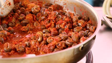 escargot simmering in rich tomato sauce