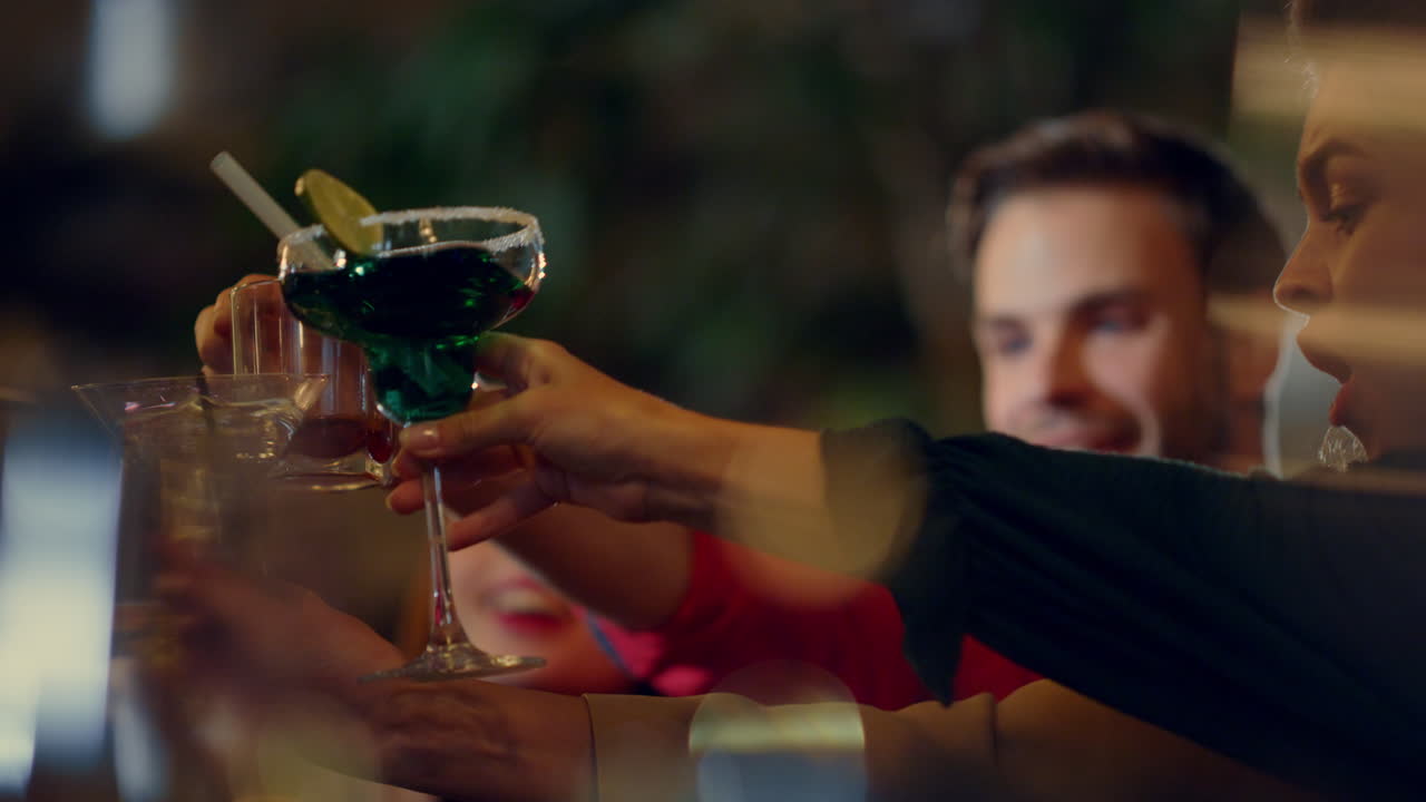 amici felici che fanno tintinnare i bicchieri alla festa, persone sorridenti che brindano al chiuso.