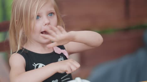 a little blonde girl shows magic tricks