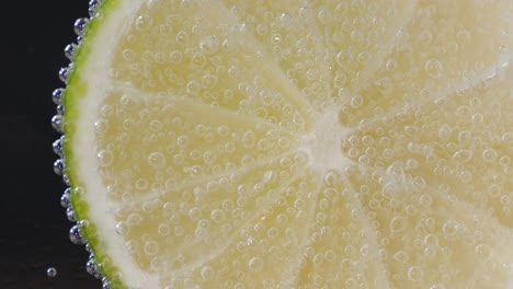 un pedazo de cal bajo el agua con burbujas de aire.