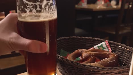 hand drinking from a beer and a bretzel in germany