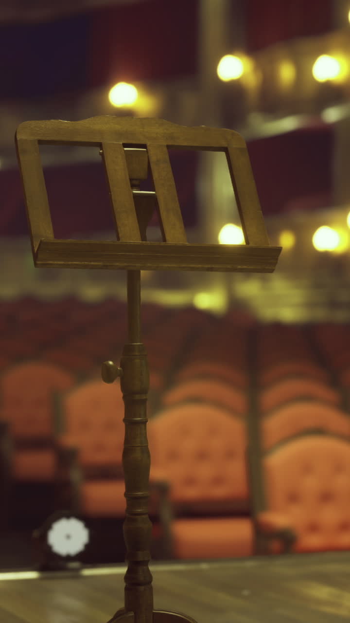Interno spettacolare di un teatro con un palco vuoto e un leggio musicale