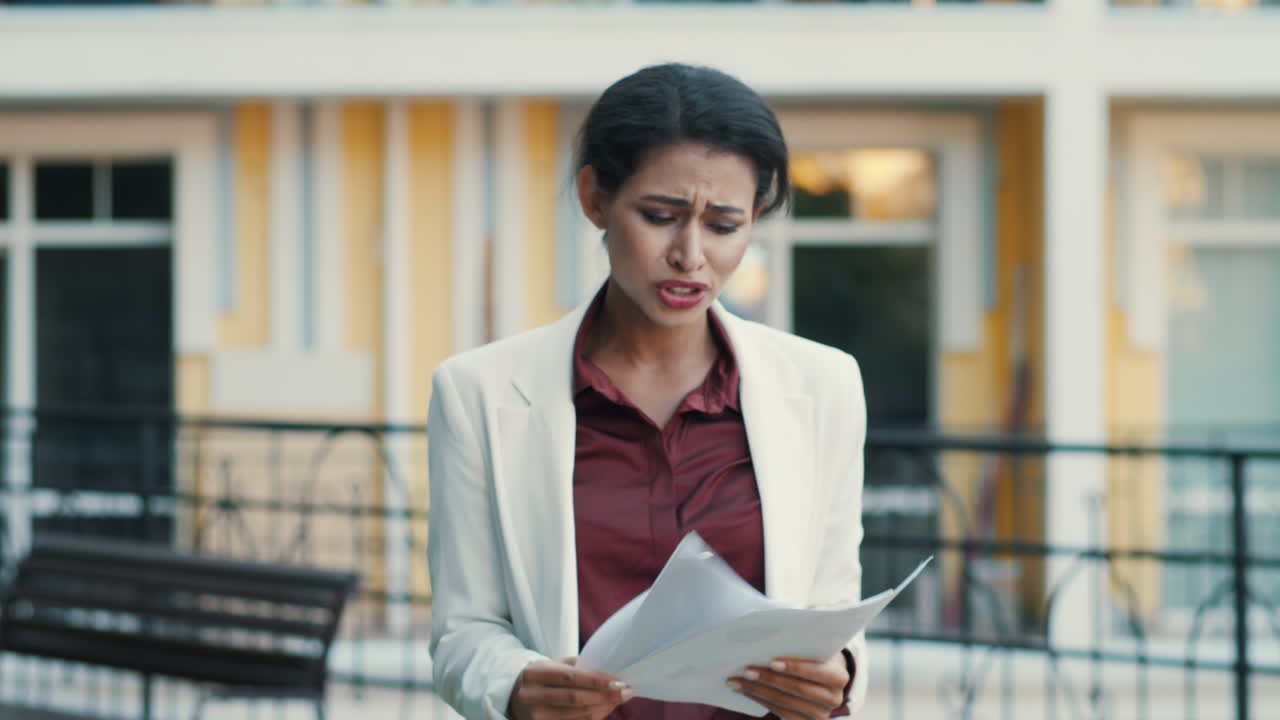 Sad businesswoman feeling upset with project data outdoors, Lady reading papers