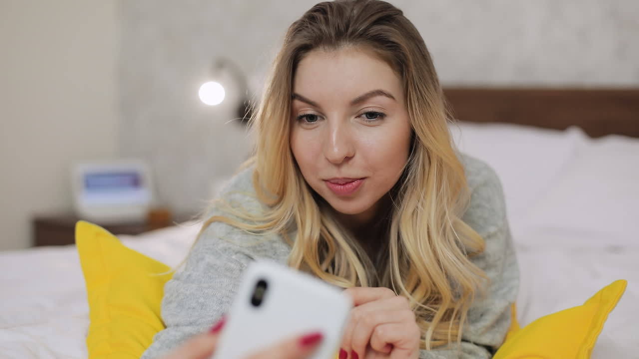 mujer usando el teléfono en la cama