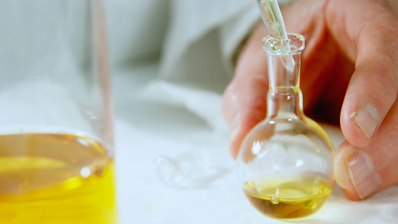 Animation of german over caucasian male scientist pouring liquid into laboratory beaker