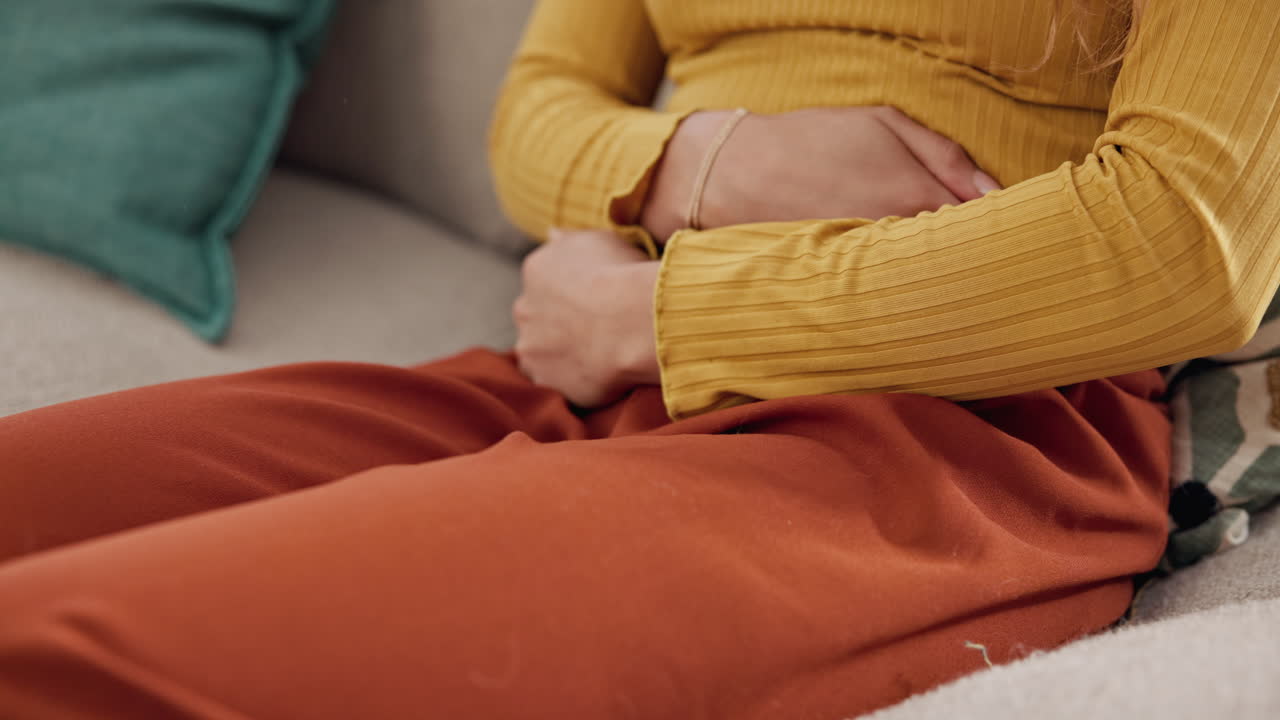 mujer sosteniendo su estómago en dolor