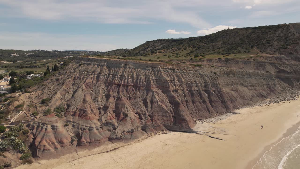 grúa sobre la ladera de un gran acantilado que bordea el flanco de praia da luz, algarve - antena