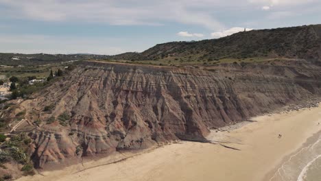 Kran-über-Großem-Klippenhang,-Der-Die-Praia-Da-Luz-Flanke-Begrenzt,-Algarve---Antenne