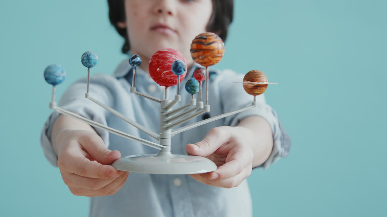 Little Boy Holding Solar System Model Toy