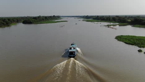 Toma-Aérea-De-Un-Dron-Después-De-Un-Barco-En-Movimiento-Lento-Que-Viajaba-Por-El-Río-Sangker-En-Camboya