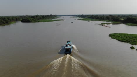 toma aérea de un dron después de un barco en movimiento lento que viajaba por el río sangker en camboya