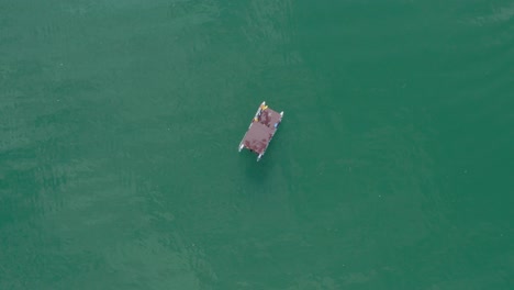 aerial top view of a raft log cabin anchored on the lake perucac , western serbia - aerial ascend