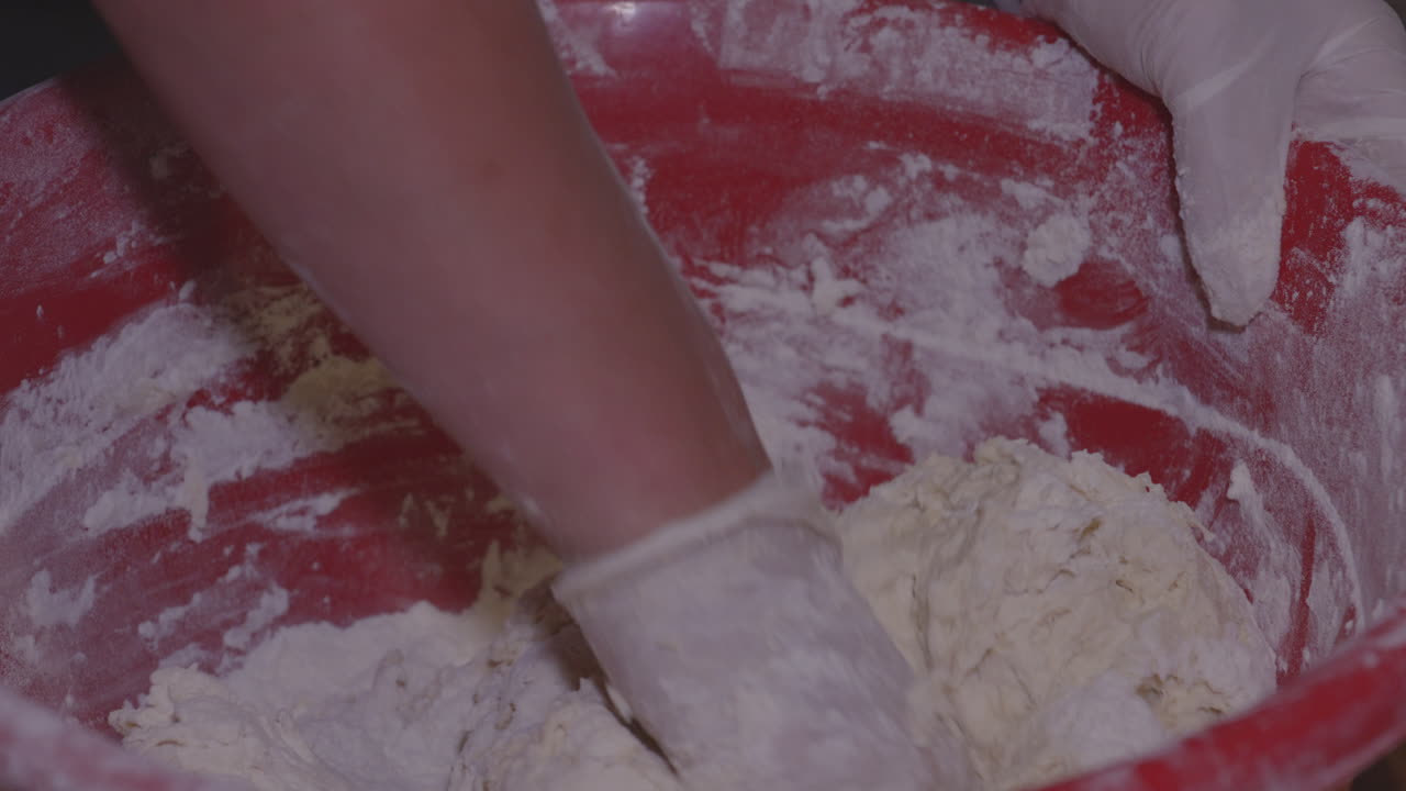 큰 그릇에 반죽을 섞는 장갑을 낀 여자 손, 조지아에서 힌칼리 만두 준비 - 클로즈업