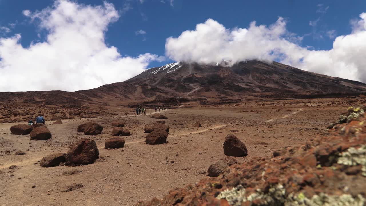 toma de lapso de tiempo de personas caminando por el sendero uhuru, hacia la cumbre del monte kilimanjaro, en un día soleado, en tanzania, áfrica