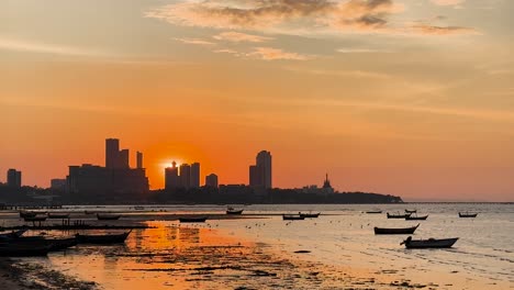 vista del atardecer con barcos y el horizonte de la ciudad