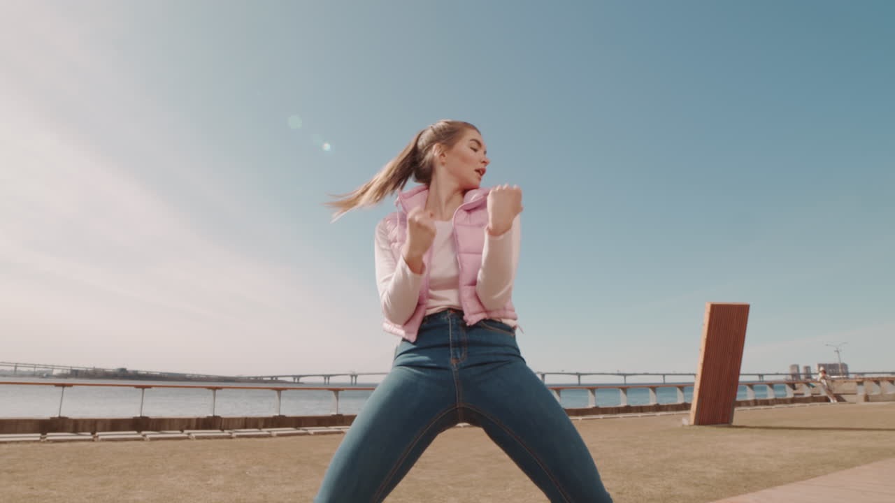 Young Woman Dancing on Embankment