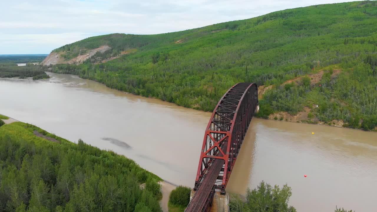 여름날 알래스카주 네나나에 있는 타나나 강을 가로지르는 미어스 메모리얼 스틸 트러스 열차 다리의 4k 드론 비디오