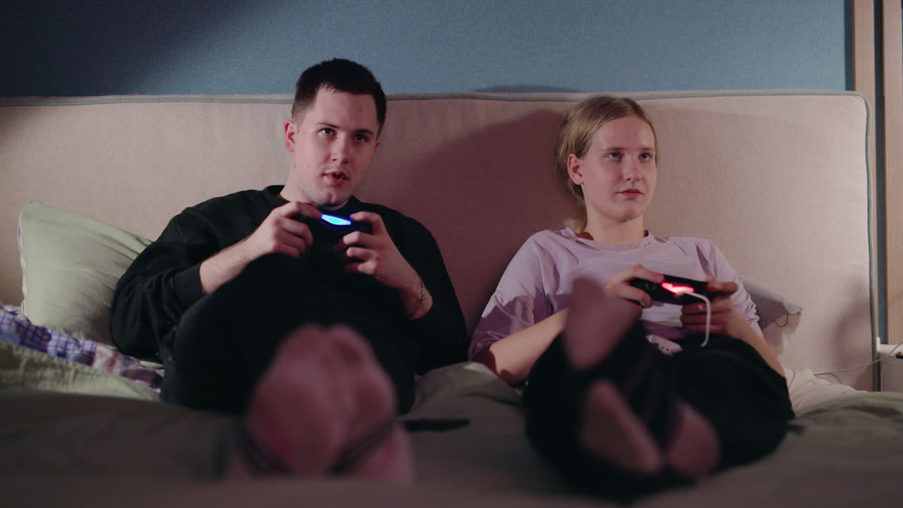 침대에서 게임하는 커플