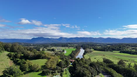 aerial footage captures dorrigo's lush greenery and winding river under clear blue skies, showcasing the region's natural beauty