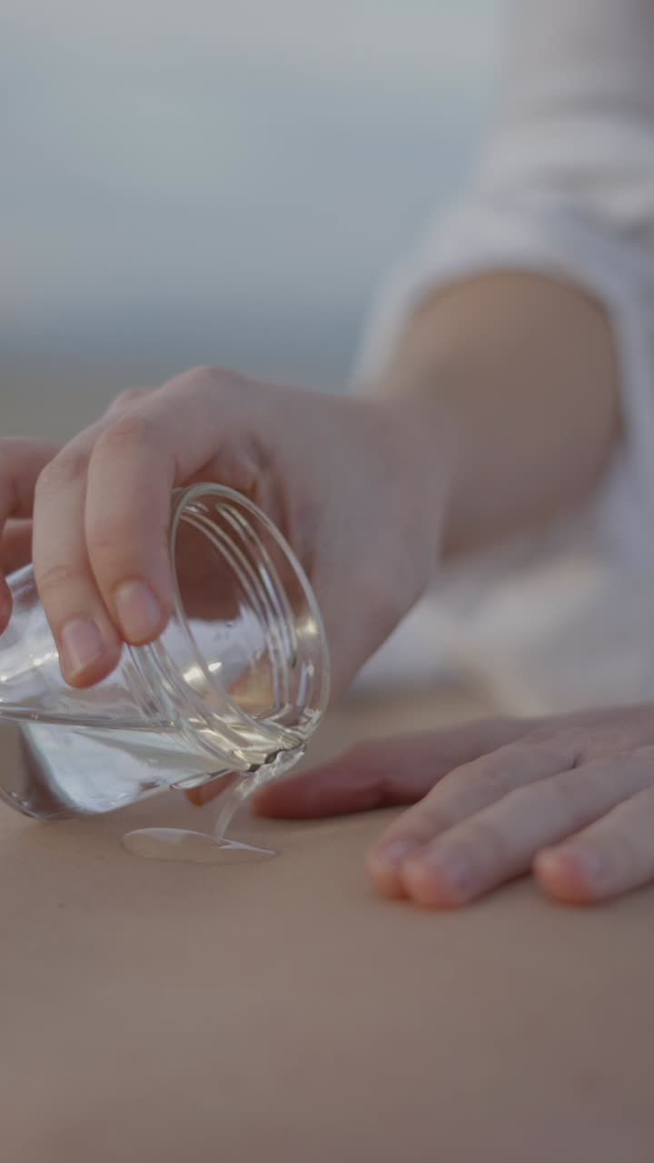 Pouring Liquid onto Skin for a Relaxing Skincare or Massage Treatment
