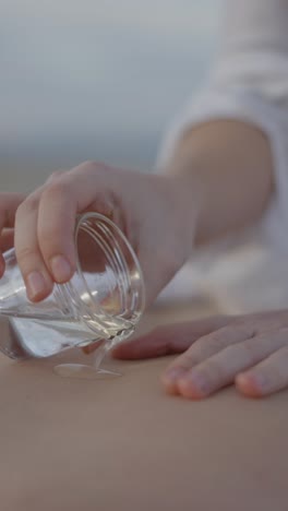 pouring liquid onto skin for a relaxing skincare or massage treatment