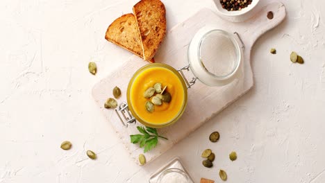 Pumpkin-soup-in-glass-jar-on-cutting-board