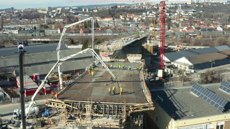 workers preparing crane cement pumps at city bridge construction site