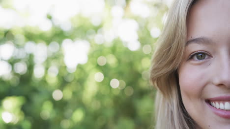 Portrait-of-happy-biracial-woman-with-blonde-hair-in-garden,-slow-motion,-copy-space