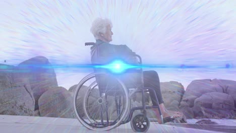animación de la luz moviéndose sobre una mujer caucásica mayor sonriente en silla de ruedas en la playa mirando al mar