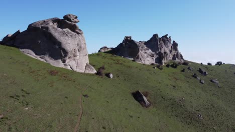 aerial: mountain top grass meadow below smooth granite rock outcrops