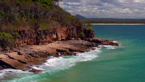 Olas-ásperas-En-El-Parque-Nacional-De-Noosa-Con-Gente-Flotando-Con-Tablas-De-Surf-En-Qld,-Australia